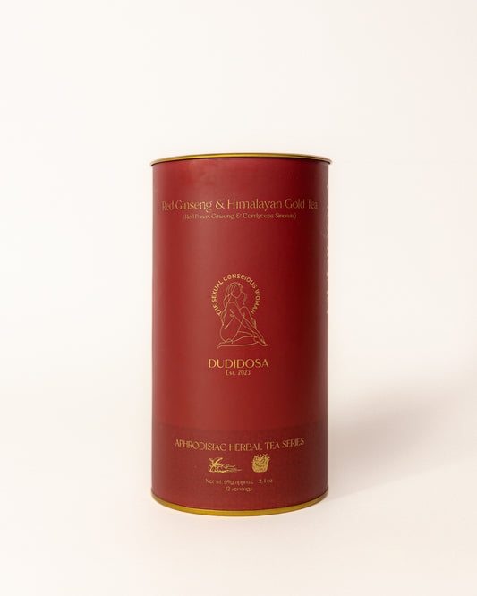 Red and gold DUDIDOSA tea tin labeled Red Ginseng & Himalayan Gold Tea. A luxurious herbal blend made with red ginseng, cordyceps, and maca. Crafted to naturally boost energy, balance hormones, and support desire.